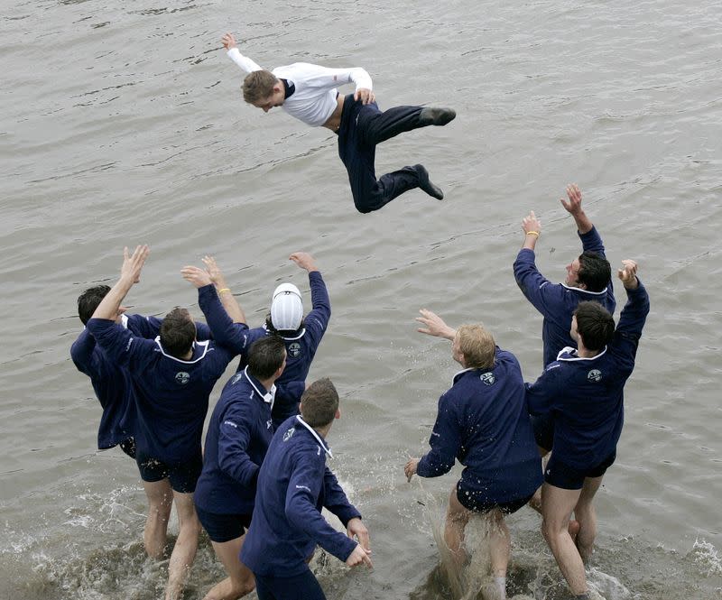 FILE PHOTO: The Oxford University Boat Race crew throw their cox Acer Nethercott into the river as they celebrate ...