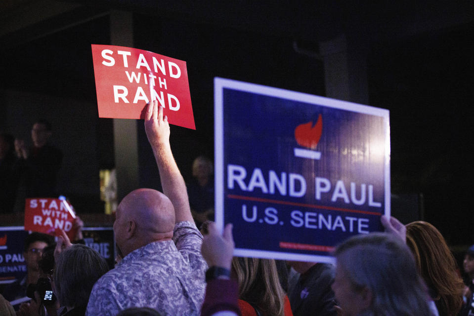 Supporters hold up signs as Sen. Rand Paul, R-Ky, gives his victory speech at the Bowling Green Country Club after defeating Democratic candidate Charles Booker, Tuesday, Nov. 8, 2022, in Bowling Green, Ky. (AP Photo/Michael Clubb)