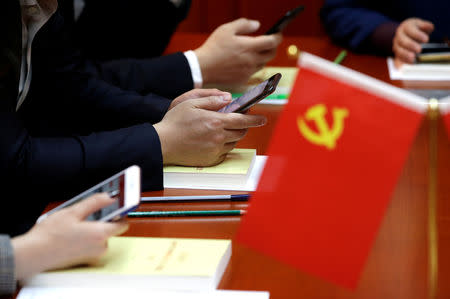 Party members, employees of at Tidal Star Group, use mobile phones during a weekly group study in an app Xuexi Qiangguo, which literally translates as 'Study to make China strong', at their party activity room in Beijing, China, February 25, 2019. Picture taken February 25, 2019. REUTERS/Jason Lee