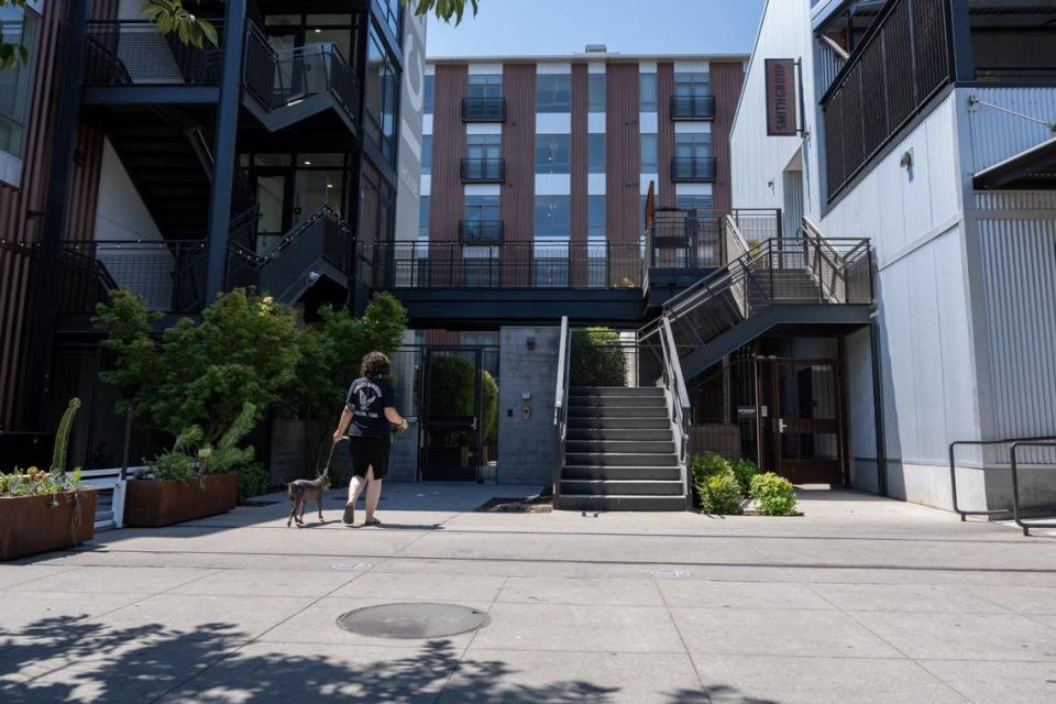 A resident walks to an apartment complex on the R Street corridor, lined by hundreds of apartments, high-end restaurants and wide, welcoming sidewalks. Paul Kitagaki Jr./pkitagaki@sacbee.com