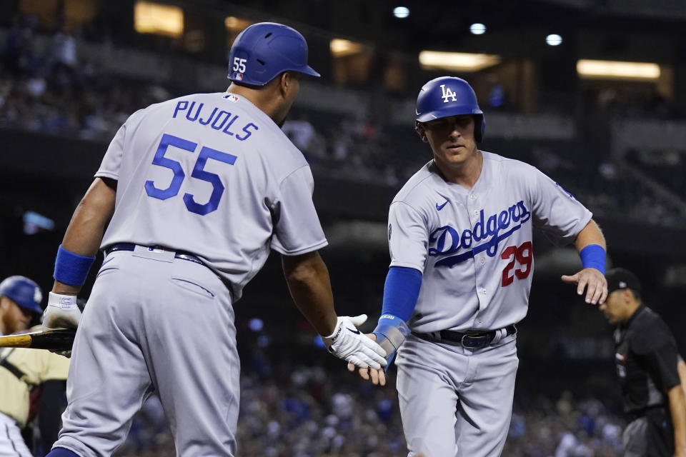 Los Angeles Dodgers' Andy Burns (29), who scored on a balk, is congratulated by Albert Pujols (55) during the eighth inning of the team's baseball game against the Arizona Diamondbacks on Friday, June 18, 2021, in Phoenix. The Dodgers won 3-0. (AP Photo/Ross D. Franklin)