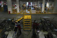 Workers sort out goods at the Chinese online retailer JD.com's warehouse in Beijing on Tuesday, Nov. 9, 2021. China's biggest online shopping day, known as "Singles' Day" on Nov. 11, is taking on a muted tone this year as regulators crack down on the technology industry and President Xi Jinping pushes for "common prosperity." (AP Photo/Andy Wong)