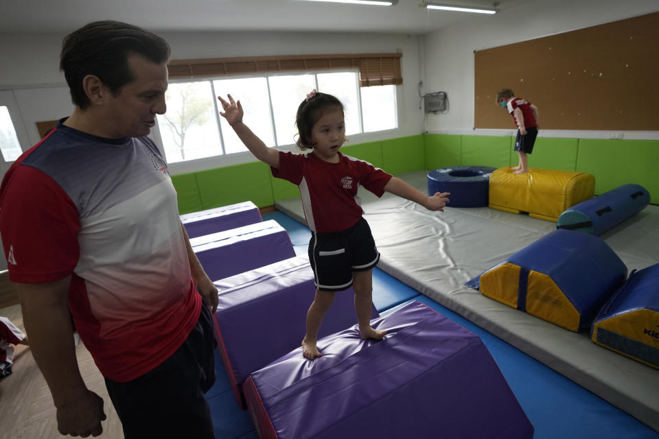 Rylae-Ann Poulin attends physical education class at Ruamrudee International School in Bangkok, Thailand, Friday, Jan. 13, 2023. Rylae-Ann was among the first to benefit from a new way of delivering gene therapy _ directly into the brain _ that experts believe holds great promise for treating a host of brain disorders. (AP Photo/Sakchai Lalit)