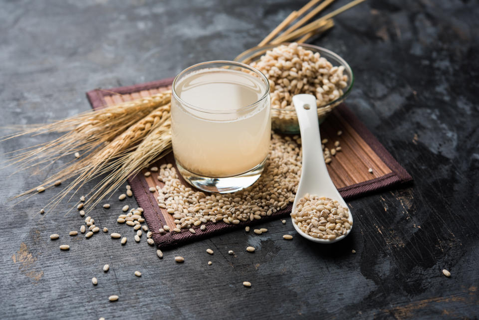 Barley water in glass with raw and cooked pearl barley wheat/seeds. selective focus