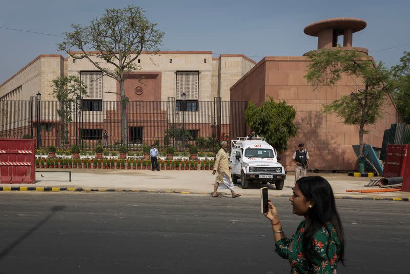 A member of media works outside the India's new parliament building before its inauguration in New Delhi