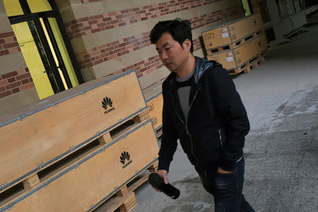 A man walks past boxes with Huawei logo inside Ox Horn campus at Songshan Lake in Dongguan, Guangdong province, China March 25, 2019. REUTERS/Tyrone Siu