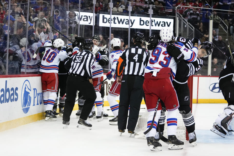 Officials break up a fight between the New Jersey Devils and the New York Rangers during the third period of an NHL hockey game Thursday, March 30, 2023, in Newark, N.J. The Devils won 2-1. (AP Photo/Frank Franklin II)