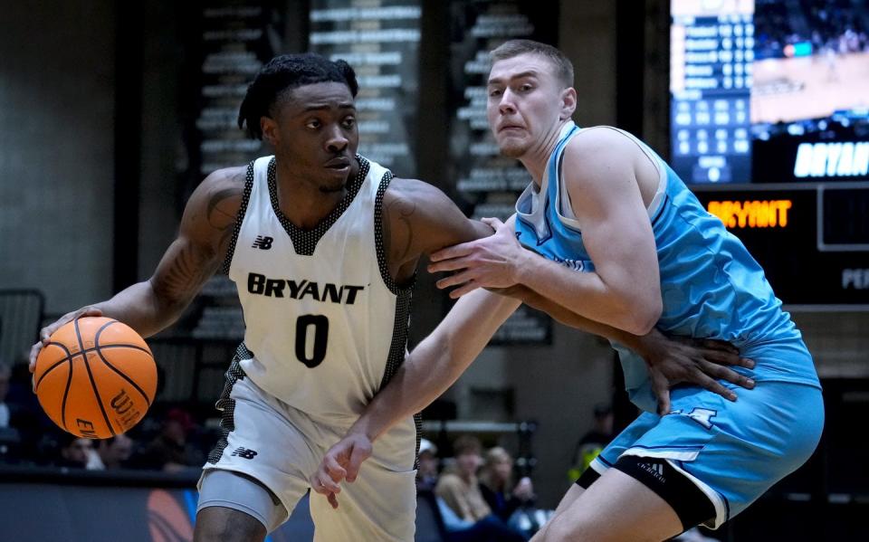 Bryant's Earl Timberlake moves to the hoop around Maine Black Bear Peter Filipovity on Thursday night at Chace Center.