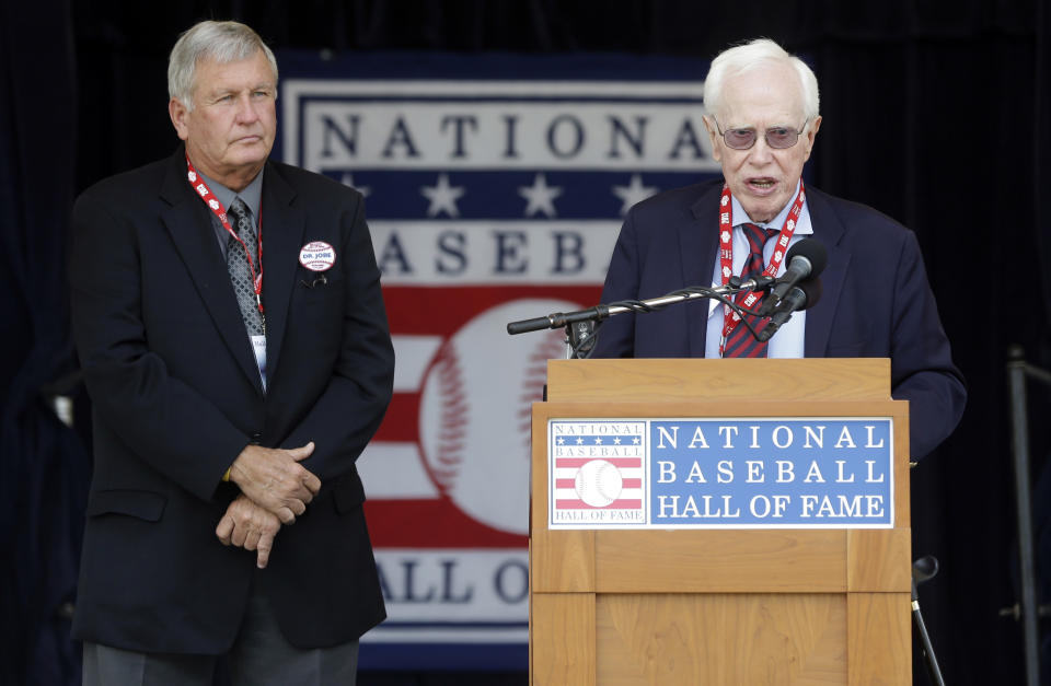 ARCHIVO - El doctor Frank Jobe (derecha), responsable de crear el procedimiento quirúrgico para reconstruir el codo -- "La Operación Tommy John" habla junto a Tommy John durante una ceremonia en el Salón de la Fama del Béisbol, en Cooperstown, Nueva York, el 27 de julio de 2023. (AP Foto/Mike Groll)