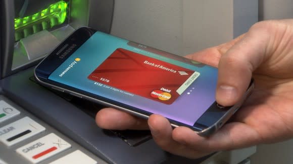 Smartphone user getting cash at Bank of America ATM.