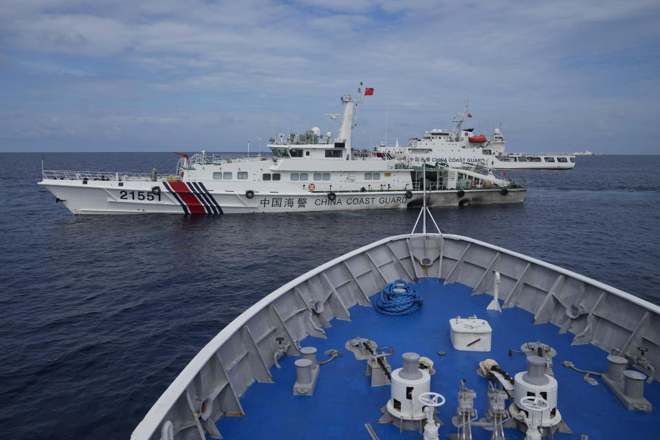 FILE - Chinese coast guard ships block Philippine coast guard BRP Cabra as it tried to head towards Second Thomas Shoal, locally known as Ayungin Shoal, at the disputed South China Sea during a rotation and resupply mission on Aug. 22, 2023. Simmering tensions in the South China Sea between China and several Southeast Asian nations now regularly spark direct confrontation, while coordinated attacks on the military-run government that seized control of Myanmar three years ago have grown to the point that most say the country is now in a civil war. It's with this backdrop that Laos, the poorest and one of the smallest countries in the Association of Southeast Asian Nations, is taking over as the bloc's rotating chair. (AP Photo/Aaron Favila, file)