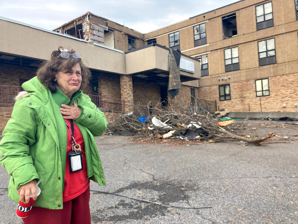 Judy Burton becomes emotional while standing outside her apartment building, which was severely damaged in Friday's tornados, in Mayfield, Ky., Sunday, Dec. 12, 2021. Burton and her dog barely escaped as one of the most devastating tornados in American history tore apart her town of 10,000 people. (AP Photo/Claire Galofaro)