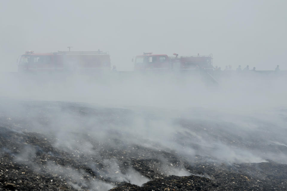 Firefighters are seen through smoke from a fire that razes through a landfill in Bekasi, on the outskirt of Jakarta, Indonesia, on Sept. 25, 2023. Pollution is causing respiratory illnesses and deaths to rise in Indonesia's island of Java, including the capital, Jakarta. Data gathered by IQAir, a Swiss air technology company, regularly ranks Jakarta as one of the most polluted cities in the world. Blue skies are a rare sight and the air often smells like fuel or heavy smoke. (AP Photo/Achmad Ibrahim)