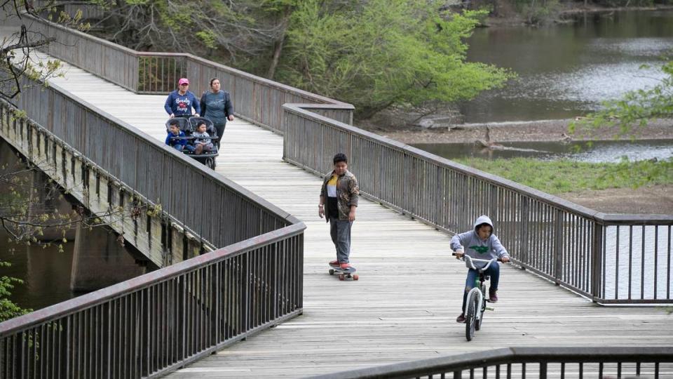 A sparse crowd of visitors make their way around Shelly Lake on Tuesday, March 31, 2020 in Raleigh,N.C. On the first full day of North Carolina’s stay-at-home order to stop the spread of the COVID-19 virus, most people were taking the order seriously by limiting their travel and practicing social distancing.