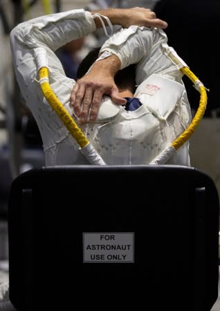 NASA Commercial Crew Astronaut Josh Cassada stretches before being placed into his space suit at NASA's Neutral Buoyancy Laboratory (NBL) training facility near the Johnson Space Center in Houston