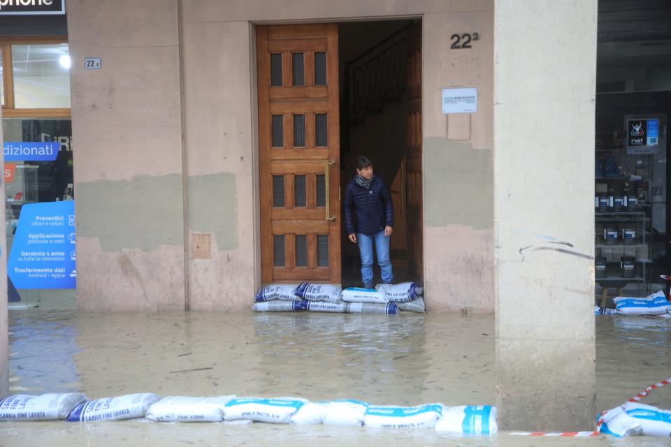 Sandbags are lined up along a flooded street in Bologna, Italy, Tuesday, May 16, 2023.