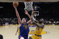 Denver Nuggets center Nikola Jokic (15) shoots against Los Angeles Lakers forward LeBron James (23) during the second half of Game 3 of an NBA basketball first-round playoff series in Los Angeles, Thursday, April 25, 2024. (AP Photo/Ashley Landis)