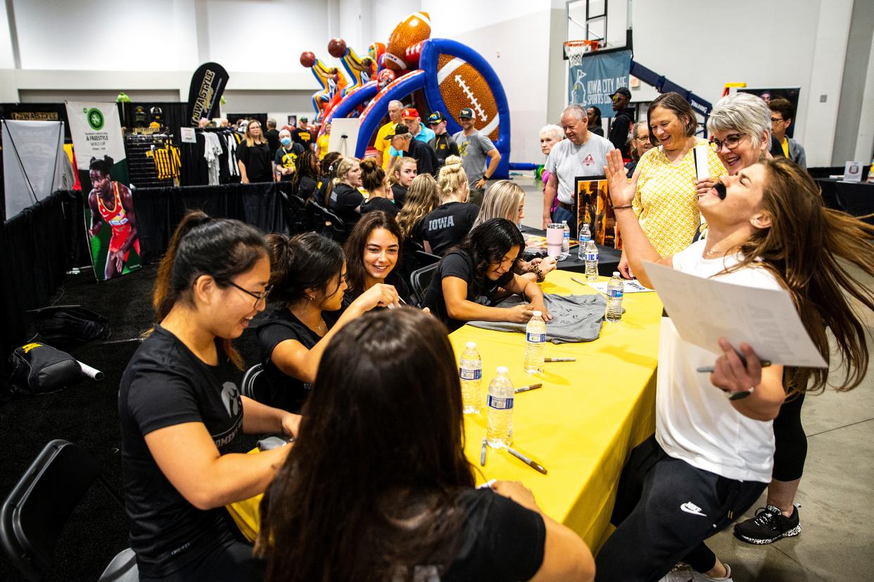 Czech freestyle wrestler Adela Hanzlickova, right, dons a fake mustache while Iowa Hawkeyes women's wrestlers sign autographs for fans during FRYfest, Friday, Sept. 2, 2022, at the Hyatt Regency Coralville Hotel & Conference Center in Coralville, Iowa.