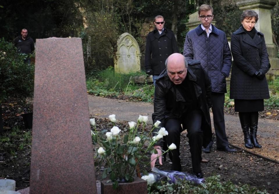 Boris Berezovsky laying flowers at the grave of Alexander Litvinenko, watched by Marina Litvinenko (right).