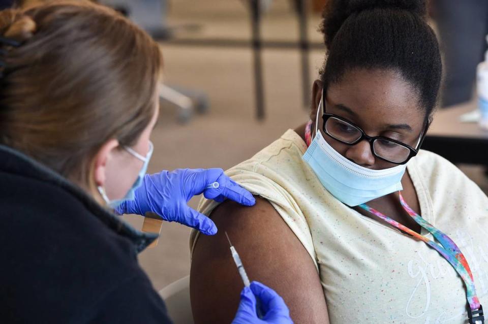 Jackson County Health Department nurse Rachel Baas talks with 18-year-old ShaNielle Collins before giving her a dose of the COVID-19 vaccine at the Grandview branch of the Mid-Continent Public Library Wednesday, July 14, 2021. The health department in June began operating vaccination clinics at Mid-Continent libraries, focusing on communities with vaccination gaps, which means either low accessibility or rates.