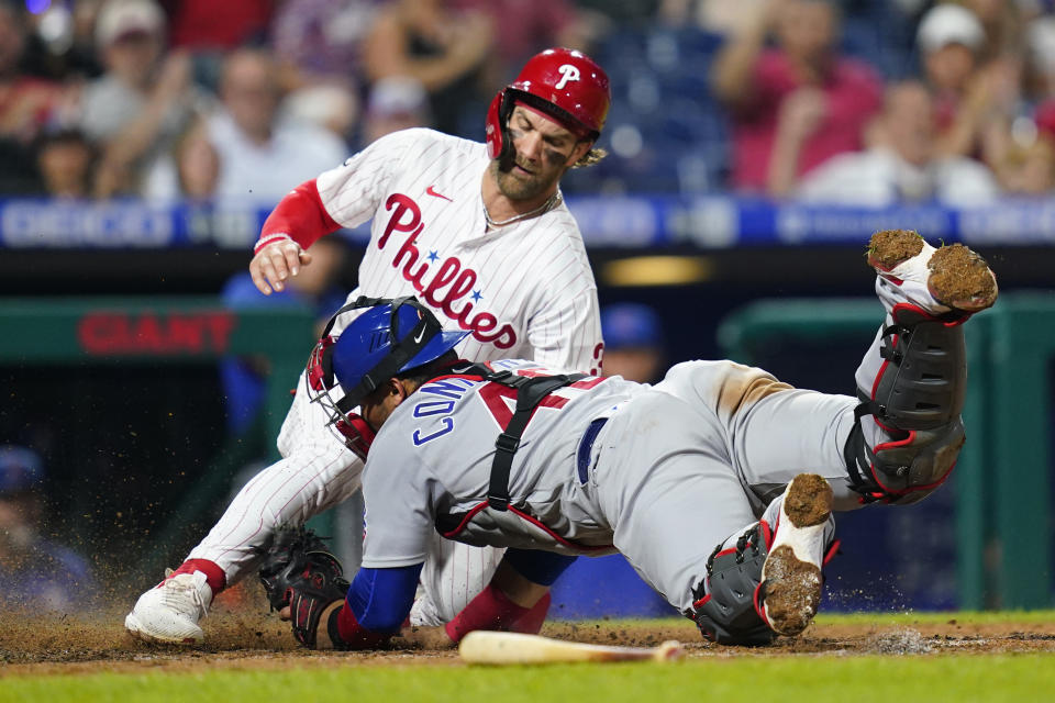 Philadelphia Phillies' Bryce Harper, left, scores past Chicago Cubs catcher Willson Contreras on a RBI-single by Didi Gregorius during the sixth inning of a baseball game, Tuesday, Sept. 14, 2021, in Philadelphia. (AP Photo/Matt Slocum)