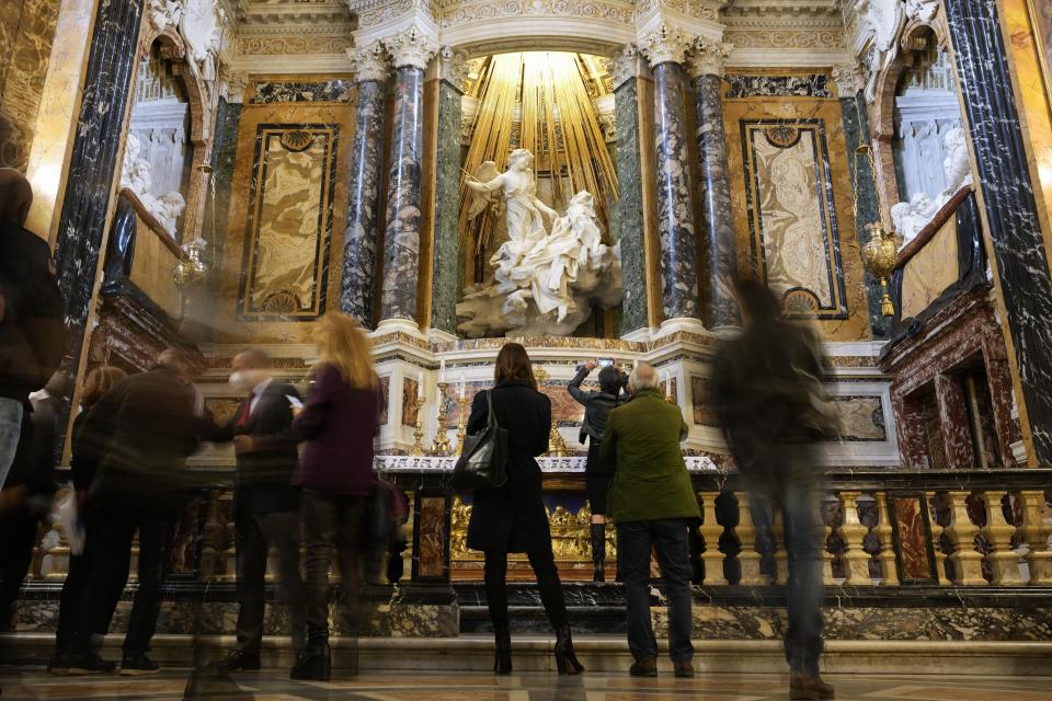 Reporters admire the Cornaro Chapel with The Ecstasy of Saint Teresa, the central sculptural marble group, during the presentation of its restoration in Santa Maria Della Vittoria Church, in Rome, Thursday, Oct. 21, 2021. The restoration involved the entire chapel, a masterpiece of the High Roman Baroque, designed and completed by Gian Lorenzo Bernini in 1653. (AP Photo/Alessandra Tarantino)