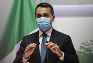 Italian Foreign Minister Luigi Di Maio adjusts the microphones as he speaks to the media during a press conference after a meeting with Cypriot Foreign Minister Nicos Christodoulides at the Foreign Ministry house in Nicosia, Cyprus, Tuesday, March 9, 2021. Maio is in Cyprus on a one-day visit. (Yiannis Kourtoglou Pool via AP)