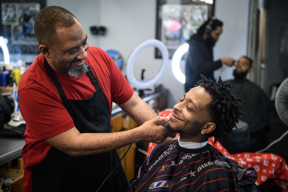 Barber Bobby Smith, left, gives a trim to his son, Storm Smith, at Platform Dzynz Barber Studio at 6257 Raeford Road.