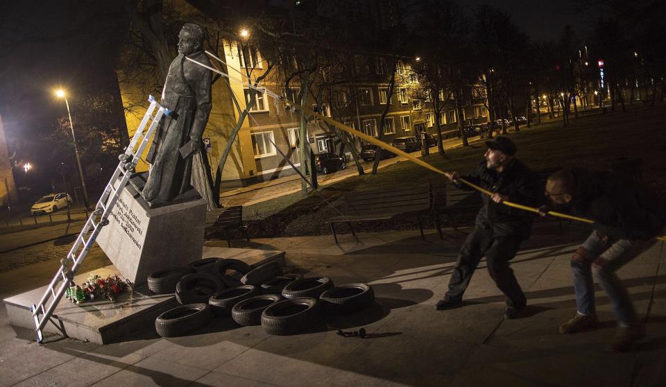 Activists in Poland pull down a statue of a prominent deceased priest, Father Henryk Jankowski, who allegedly abused minors sexually, in Gdansk, Poland, on Thursday Feb. 21, 2019. The activists said it was an act of protest against the Polish Catholic Church for failing in resolving the problem of clergy sex abuse. The protest comes as Pope Francis has gathered church leaders from around the world at the Vatican to grapple with the church's sex abuse crisis. (AP Photo/Bartek Sabela/Gazeta Wyborcza)