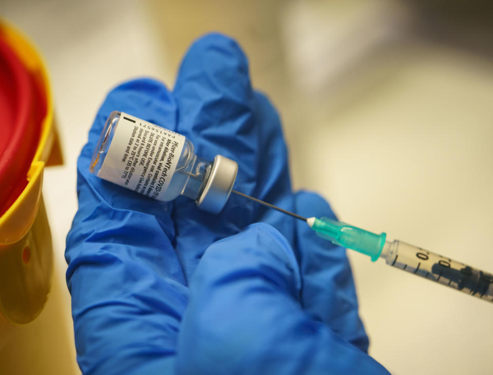 A medical worker holds a syringe with the Biontech-Pfizer Covid-19 vaccine during vaccination at the corona vaccination center installed in the congress hall of Darmstadt, western Germany, on January 19, 2021, as the federal state of Hesse starts vaccinations in six centers simoutlaneously. -  (Photo by Frank Rumpenhorst / POOL / AFP) (Photo by FRANK RUMPENHORST/POOL/AFP via Getty Images)