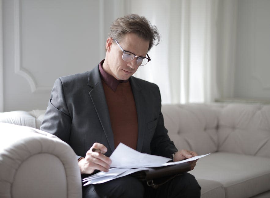 Hombre Ejecutivo Con Clase Leyendo Documentos En El Sofá