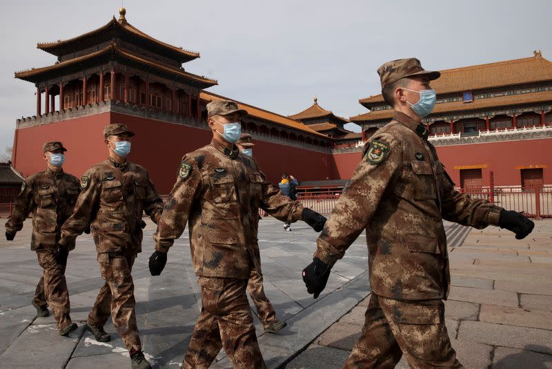 Paramilitary police officers walk in formation outside the Forbidden City near the venue of the upcoming National People's Congress (NPC) in Beijing