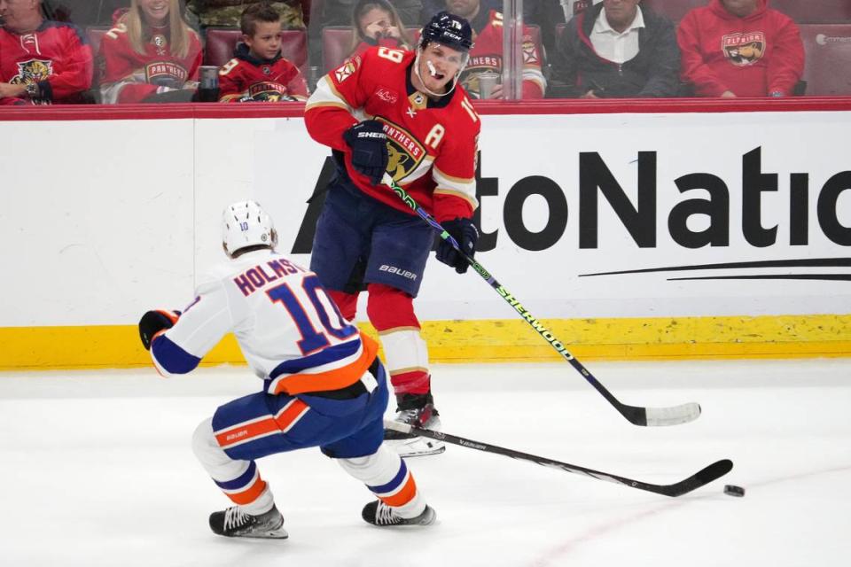 Dec 2, 2023; Sunrise, Florida, USA; Florida Panthers left wing Matthew Tkachuk (19) passes the puck away from New York Islanders right wing Simon Holmstrom (10) during the first period at Amerant Bank Arena.