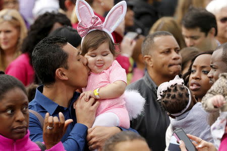 A little girl gets a kiss on the cheek as families cover the South Lawn during the annual Easter Egg Roll at the White House in Washington March 28, 2016. REUTERS/Jonathan Ernst