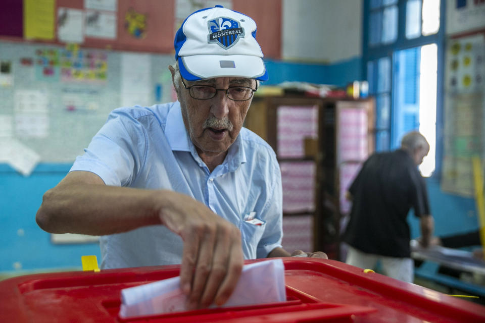 A voter casts his ballot inside a polling station during a parliamentary election in La Marsa, outside Tunis, Tunisia, Sunday, Oct. 6, 2019. Tunisians were electing a new parliament Sunday amid a tumultuous political season, with a moderate Islamist party and a jailed tycoon's populist movement vying to come out on top of a crowded field. (AP Photo/Riadh Dridi)