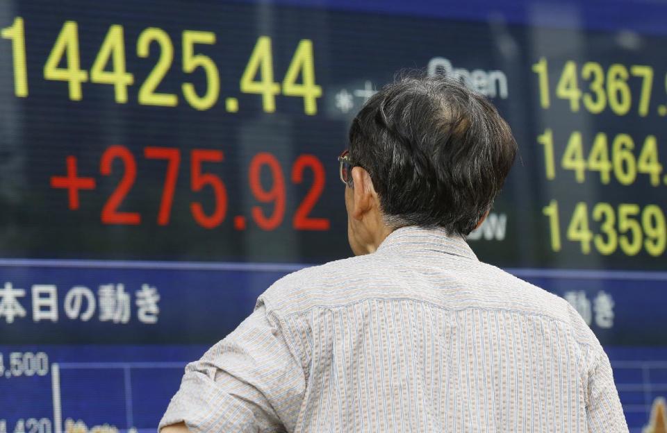 A man watches an electronic stock indicator of a securities firm in Tokyo, Tuesday, May 13, 2014. Asian stock markets rose after Wall Street indexes hit record highs, with Japan's Nikkei 225 leading gains as the yen weakened. The Nikkei ended up 275.92 points at 14,425.44 on Tuesday. (AP Photo/Shizuo Kambayashi)