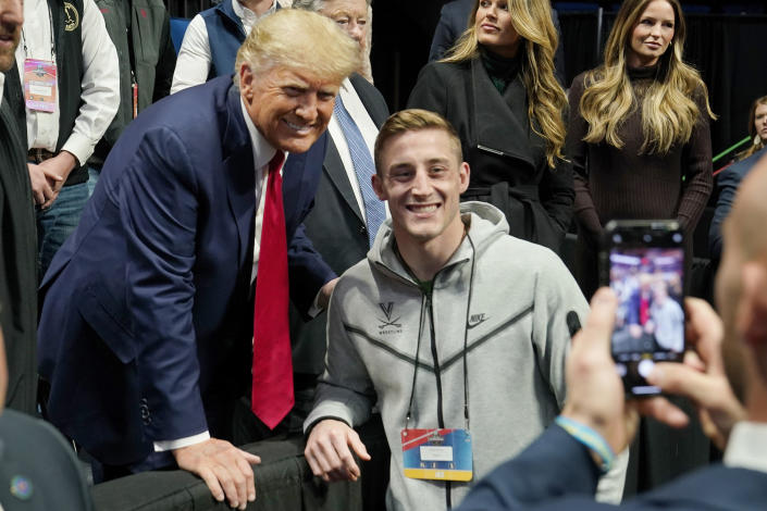 Former President Donald J. Trump, left, poses for a photo with Virginia wrestler Justin McCoy, right, at the NCAA Wrestling Championships, Saturday, March 18, 2023, in Tulsa, Okla. (AP Photo/Sue Ogrocki)