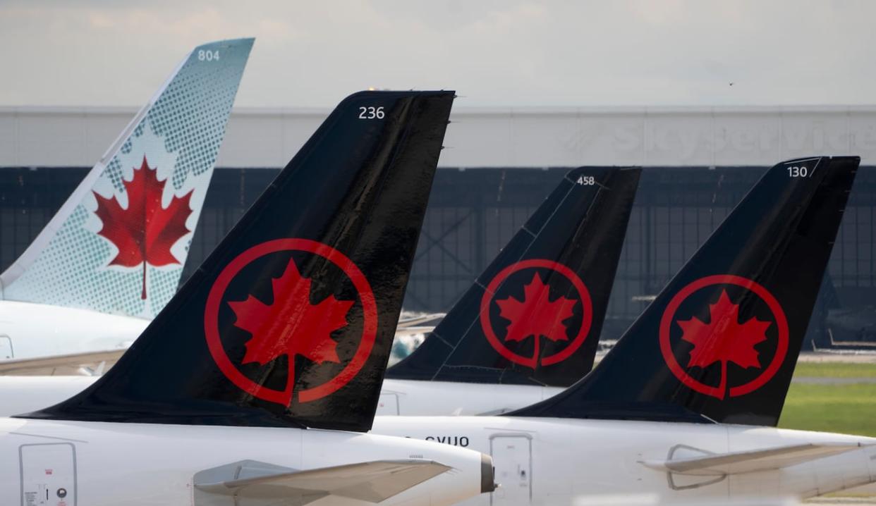 Air Canada logos are seen on the tails of planes at the airport in Montreal in June.  Mohammad Al-Fadle says his plane was still on the Pearson airport tarmac when he tried to retrieve his bag. (Adrian Wyld/The Canadian Press - image credit)