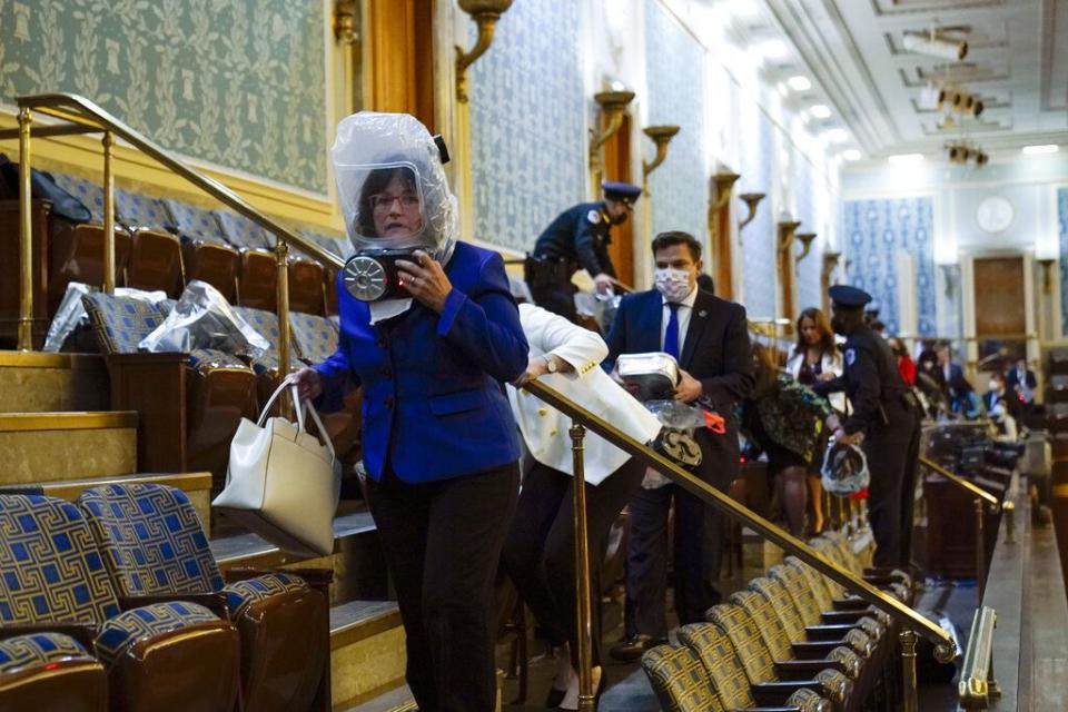 People shelter in the House gallery as protesters try to break into the House Chamber at the U.S. Capitol on Wednesday, Jan. 6, 2021, in Washington. (AP Photo/Andrew Harnik)