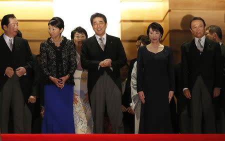 Japan's Prime Minister Shinzo Abe (front C) exchanges smiles with his cabinet ministers, including Economy, Trade and Industry Minister Yuko Obuchi (front 2nd L), Internal Affairs and Communications Minister Sanae Takaichi (front 2nd R), Deputy Prime Minister and Finance Minister Taro Aso (R) and others as they prepare for a photo session at his official residence in Tokyo September 3, 2014. REUTERS/Toru Hanai