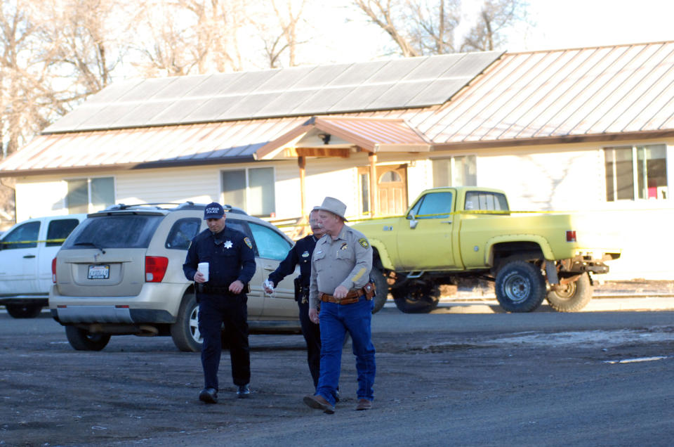Modoc County Sheriff and Coroner Mike Poindexter, right, walks away from the Cedarville Rancheria tribal headquarters building in Alturas, Calif., on Friday, Feb. 21, 2014. Police say an eviction hearing at the headquarters turned deadly Thursday as a woman who once served as a tribal leader allegedly opened fire, killing four people and critically wounding two others in a gun and knife attack. (AP Photo/Jeff Barnard)