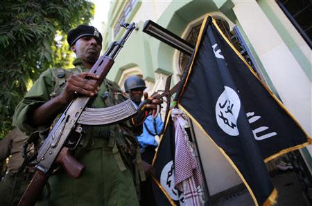 A police officer holds a flag hanged by Muslim youths at Masjid Mussa Mosque in the coastal town of Mombasa February 2, 2014. REUTERS/Joseph Okanga