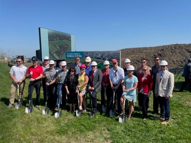 Norwalk officials, developers and Iowa Economic Development Authority Director Debi Durham, center wearing black, held a groundbreaking ceremony Thursday, May 12, 2022, for the 70-acre Norwalk Central complex.