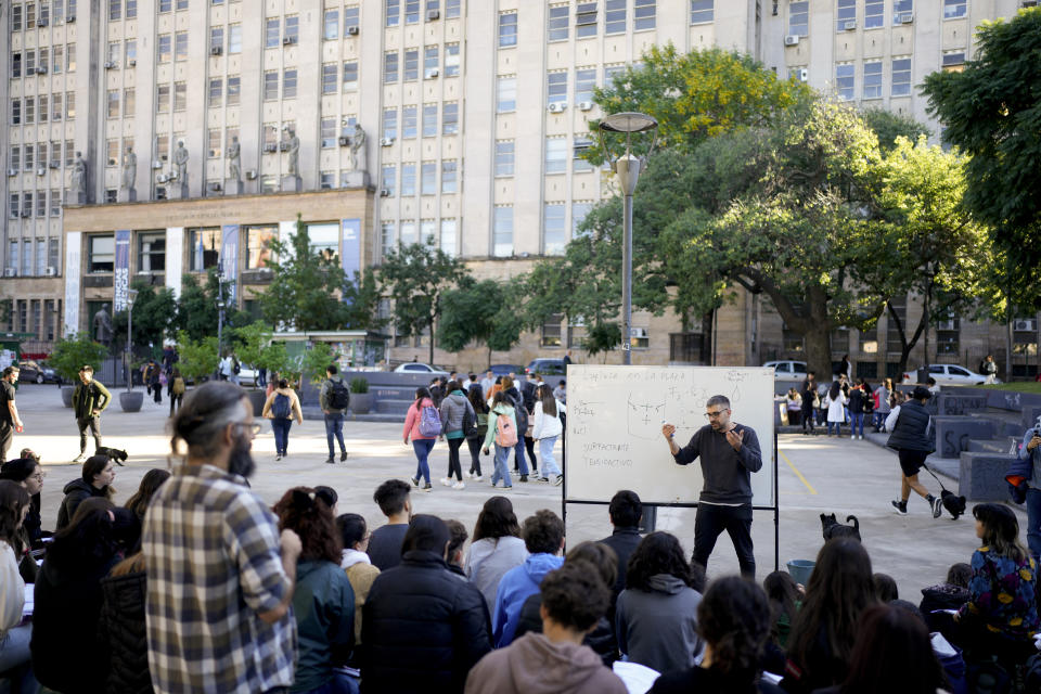 Estudiantes de la Universidad de Buenos Aires (UBA) toman clase en la calle en Buenos Aires, Argentina, el jueves 18 de abril de 2024. La UBA llevó al exterior las clases como protesta por el congelamiento de su presupuesto dispuesto por el presidente argentino, Javier Milei, como parte de sus medidas de austeridad. (AP Foto/Natacha Pisarenko)