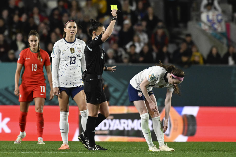 Referee Rebecca Welch shows a yellow card to United States' Rose Lavelle, right during the Women's World Cup Group E soccer match between Portugal and the United States at Eden Park in Auckland, New Zealand, Tuesday, Aug. 1, 2023. (AP Photo/Andrew Cornaga)