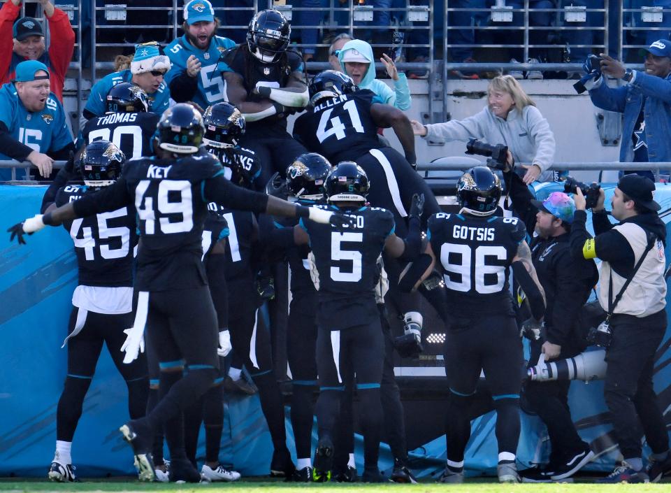 Members of the Jaguars celebrate in the stands after Rayshawn Jenkins (2) returned an interception 52 yards for a touchdown in overtime to give Jacksonville a 40-34 win over Dallas on Sunday.