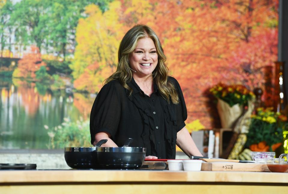 Valerie Bertinelli stands behind a cooktop counter during a Food Network event