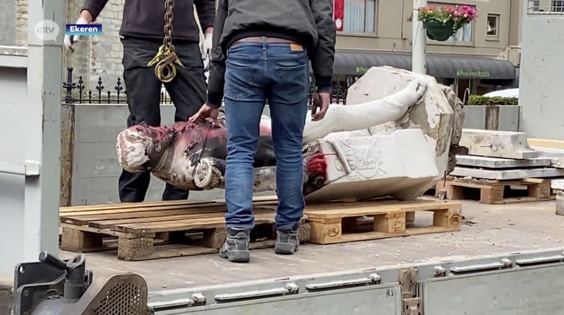 A damaged statue of former Belgian King Leopold II is seen being removed for possible renovation in Ekeren