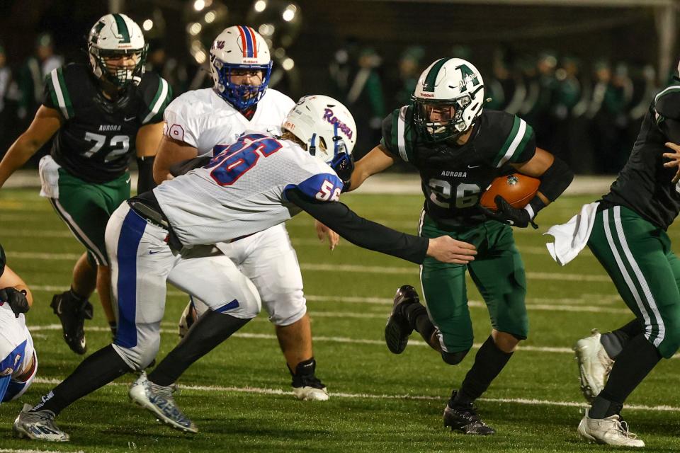 Aurora senior Aiden Henderson tries to sidestep Ravenna senior Christian Neff during Friday night’s Division III playoff game at Aurora High School.