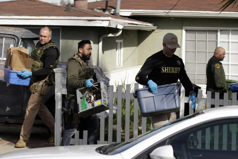 Member of the Los Angeles Sheriffs Dept. remove items after a searching a home in connection with a cold case Wednesday, Feb. 5, 2020, in Los Angeles. Search warrants were served Wednesday at locations in California and Washington state in the investigation of the disappearance of Kristin Smart, the California Polytechnic State University, San Luis Obispo student who disappeared in 1996. (AP Photo/Marcio Jose Sanchez)